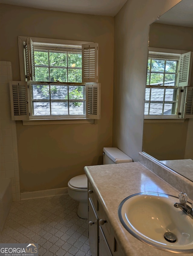 full bathroom with vanity, plenty of natural light, toilet, and tile patterned floors