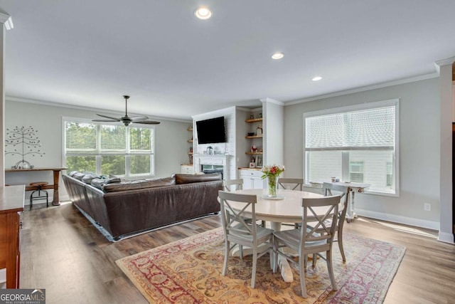 dining room with a wealth of natural light, light hardwood / wood-style flooring, and ornamental molding