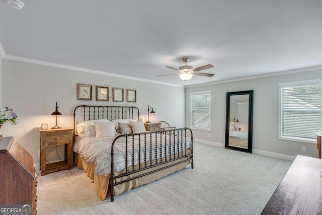 carpeted bedroom featuring ceiling fan and crown molding