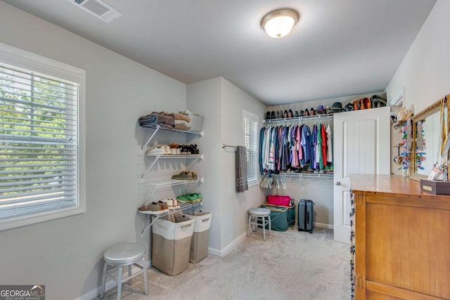 spacious closet featuring light colored carpet