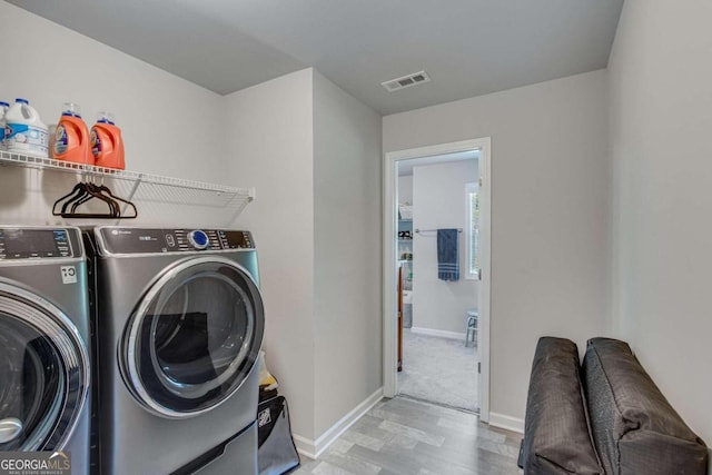 laundry area featuring light colored carpet and washer and clothes dryer