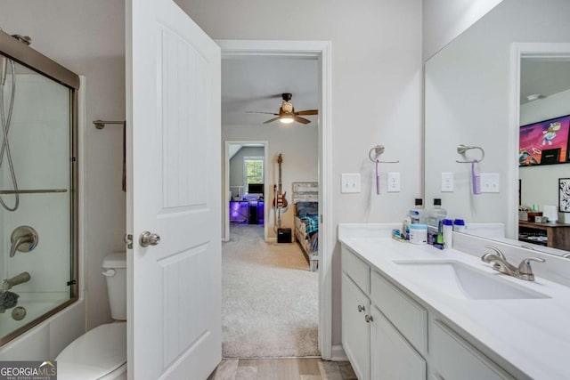 full bathroom featuring ceiling fan, shower / bath combination with glass door, toilet, and vanity