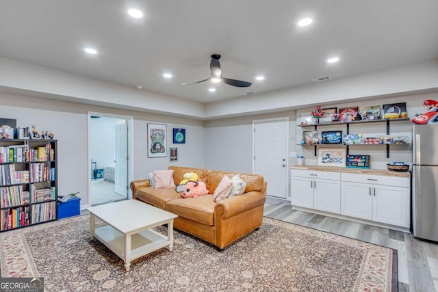 living room featuring ceiling fan and light wood-type flooring