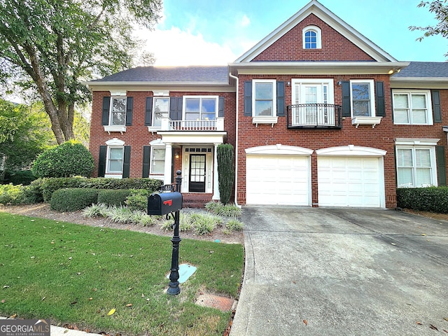 view of front of property with a balcony, a front lawn, and a garage