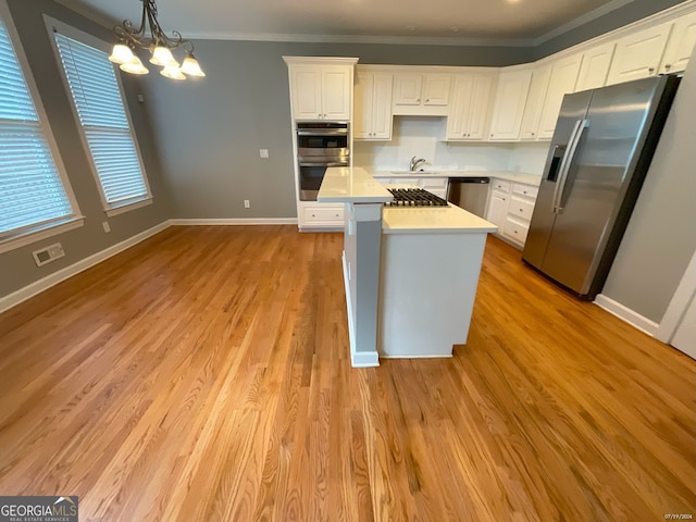 kitchen featuring light hardwood / wood-style flooring, decorative light fixtures, stainless steel appliances, an inviting chandelier, and white cabinets