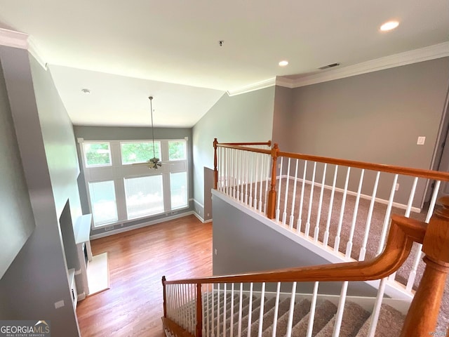 stairway featuring ceiling fan, vaulted ceiling, hardwood / wood-style floors, and ornamental molding