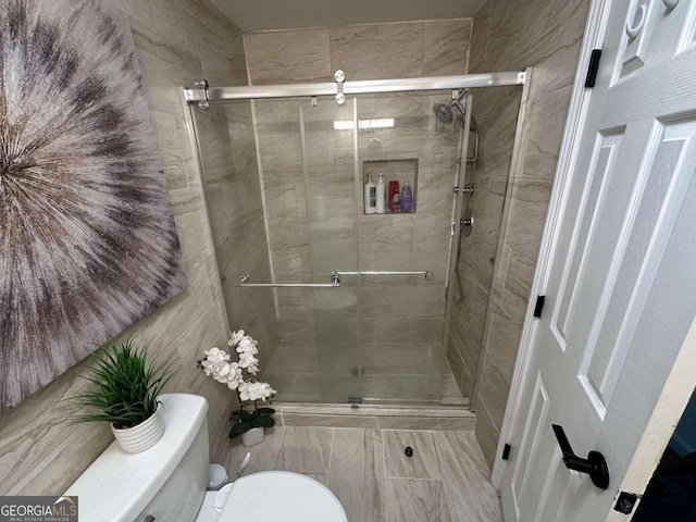 bathroom featuring tile walls, toilet, and walk in shower