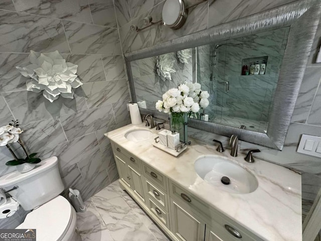 bathroom with toilet, dual bowl vanity, tile patterned floors, and tile walls