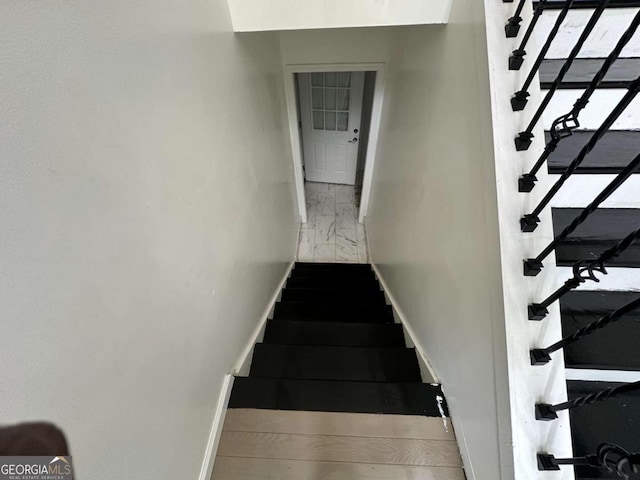 stairs featuring hardwood / wood-style floors