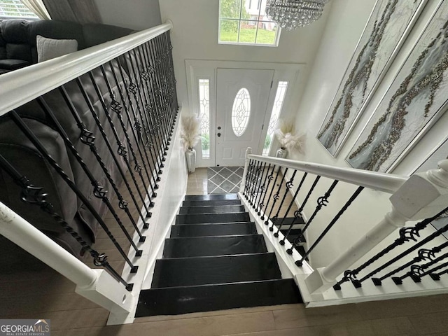 tiled entryway with a notable chandelier and a high ceiling