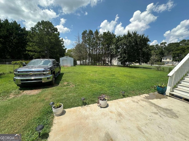 view of yard with a storage shed and a patio