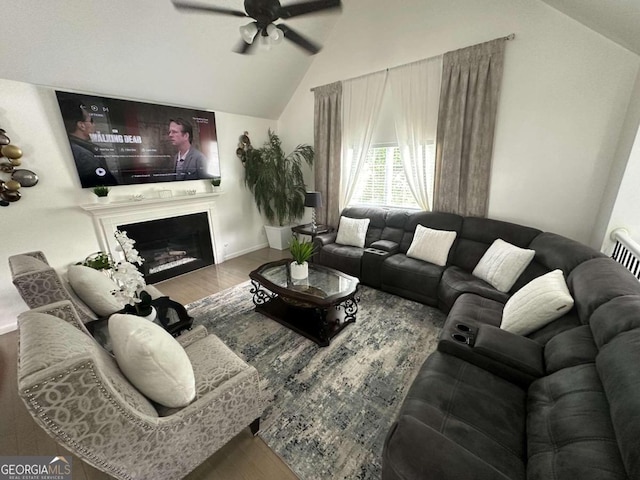 living room with ceiling fan, lofted ceiling, and hardwood / wood-style flooring