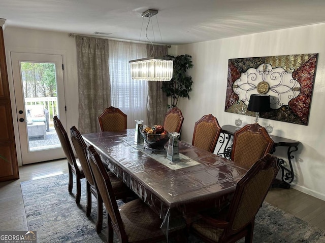 dining space featuring hardwood / wood-style floors and a chandelier