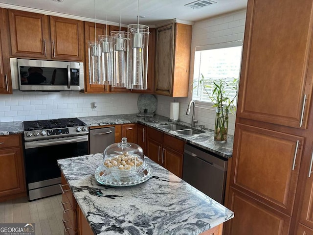 kitchen with backsplash, sink, stainless steel appliances, and stone countertops