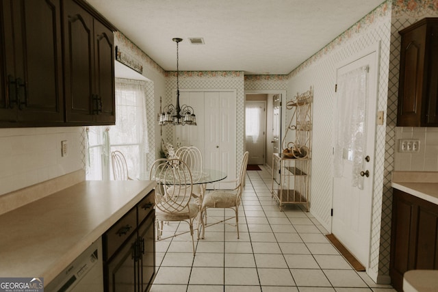 kitchen featuring pendant lighting, a healthy amount of sunlight, dark brown cabinets, and light tile patterned floors