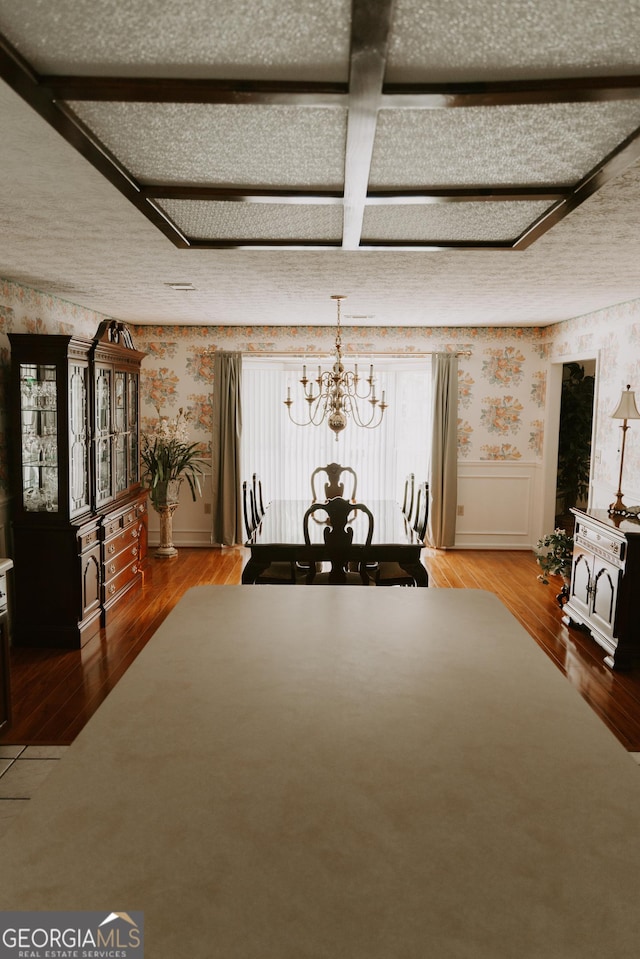 unfurnished dining area featuring hardwood / wood-style floors and a chandelier