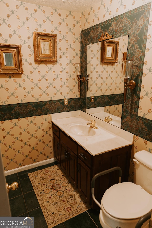 bathroom featuring vanity, a textured ceiling, tile patterned floors, and toilet