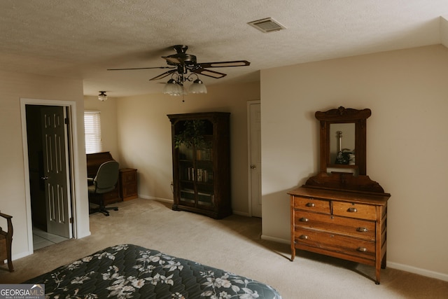 carpeted bedroom featuring ceiling fan and a textured ceiling