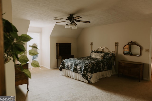 bedroom featuring ceiling fan, carpet, lofted ceiling, and a textured ceiling