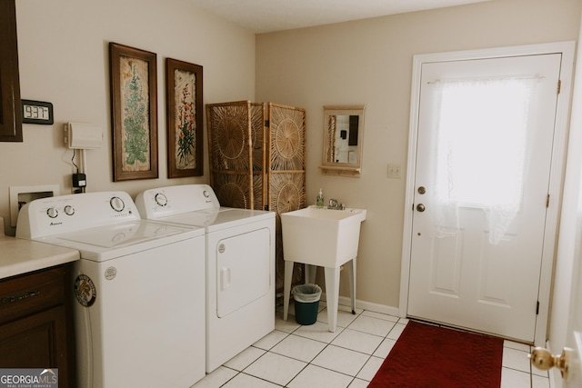 laundry room featuring sink, light tile patterned floors, and washer and clothes dryer