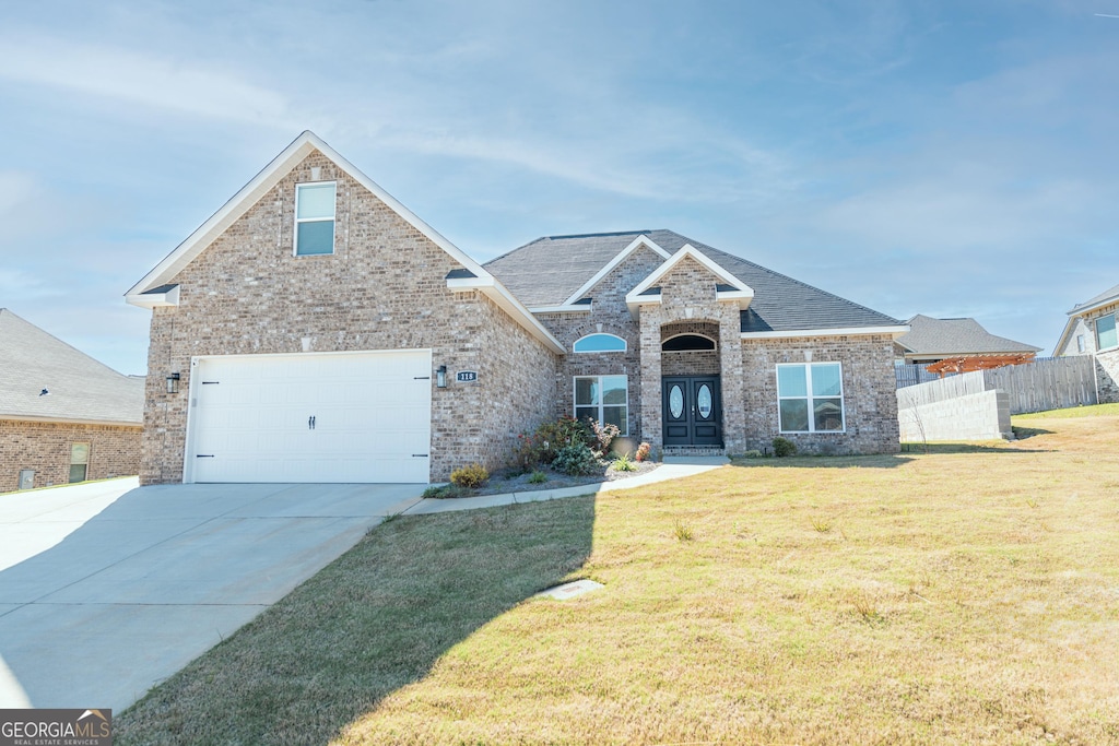 view of front of property featuring a garage and a front lawn