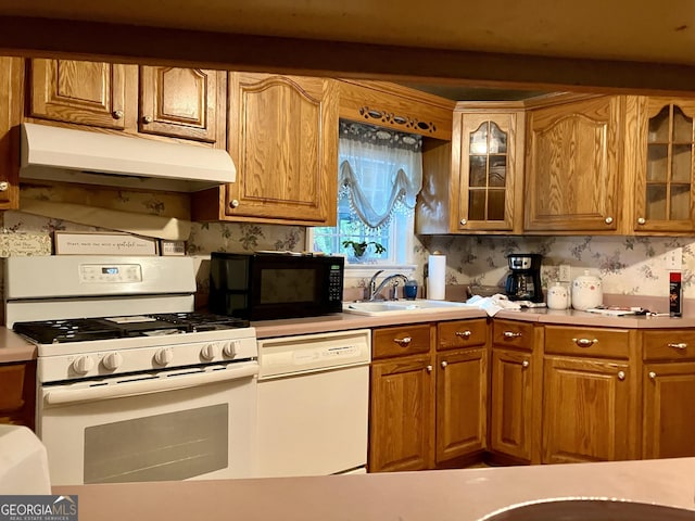 kitchen with sink, white appliances, and tasteful backsplash