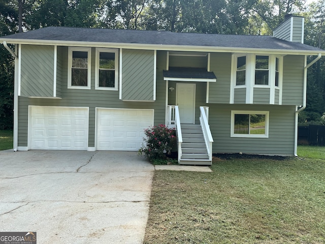 bi-level home with a garage and a front lawn