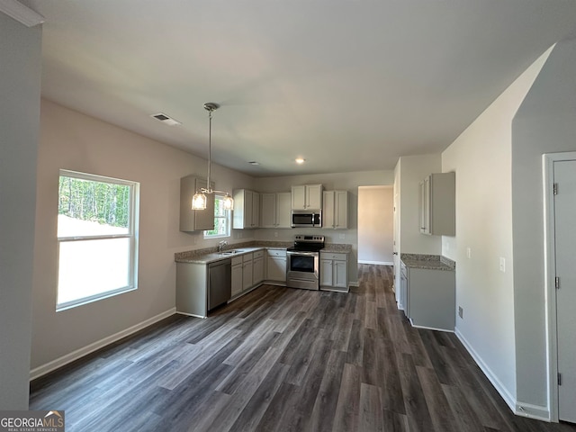 kitchen featuring sink, stainless steel appliances, pendant lighting, and dark wood-type flooring