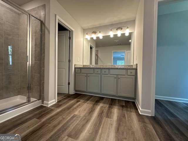 bathroom with wood-type flooring, walk in shower, and vanity