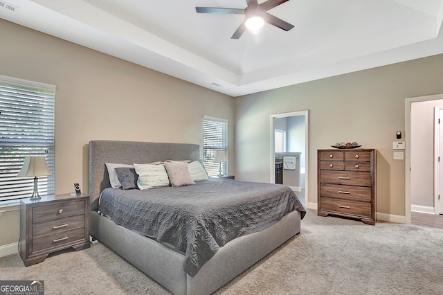 bedroom featuring ceiling fan, light colored carpet, and multiple windows