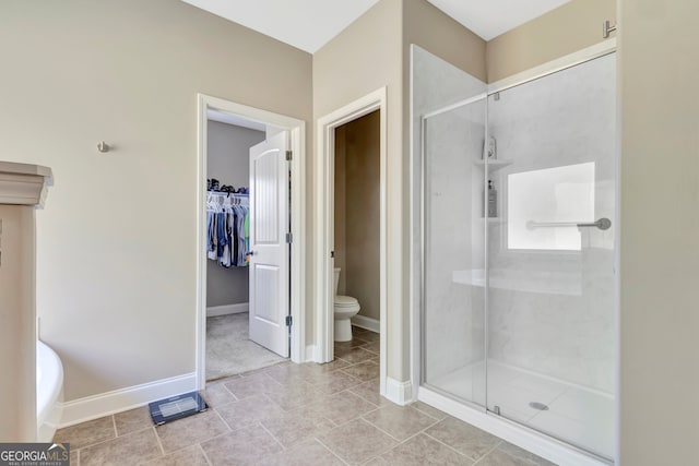 bathroom with tile patterned floors, walk in shower, and toilet