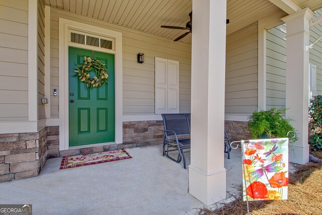 view of exterior entry featuring ceiling fan and covered porch