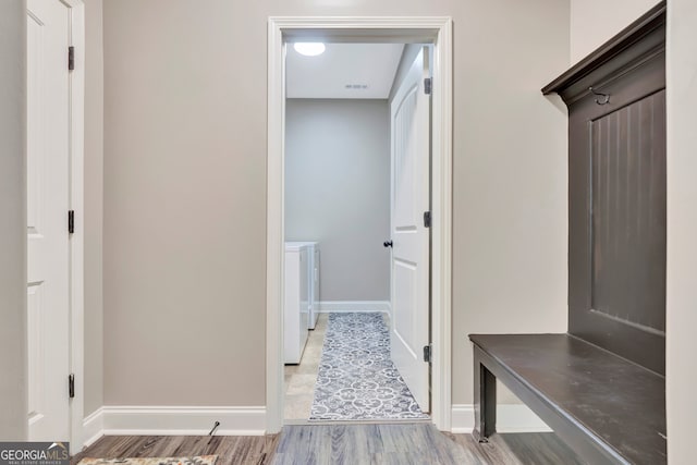 mudroom with washing machine and dryer and wood-type flooring