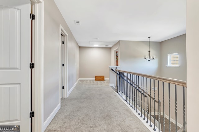 corridor featuring carpet flooring and a chandelier