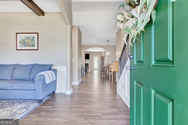 entryway with beamed ceiling and wood-type flooring