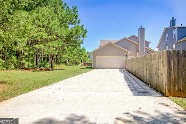 view of property exterior featuring a garage, fence, a lawn, and concrete driveway