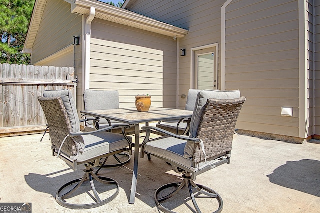 view of patio featuring outdoor dining space and fence