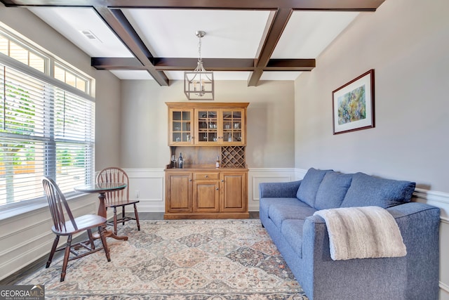 living room featuring hardwood / wood-style floors, coffered ceiling, and beamed ceiling