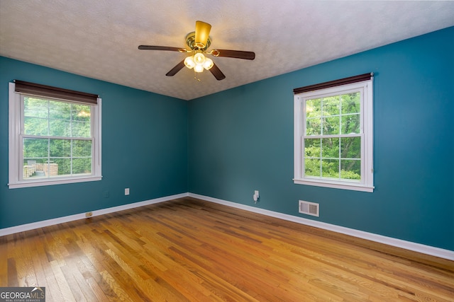 unfurnished room with light hardwood / wood-style floors, a textured ceiling, and ceiling fan