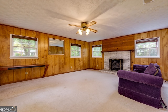 carpeted living room with a wealth of natural light and wooden walls