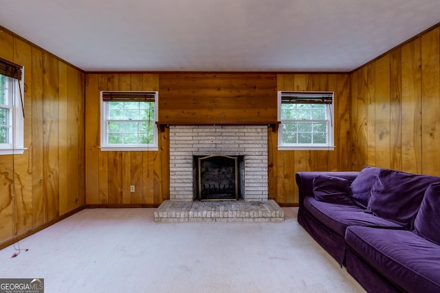 carpeted living room featuring a fireplace, a healthy amount of sunlight, and wood walls