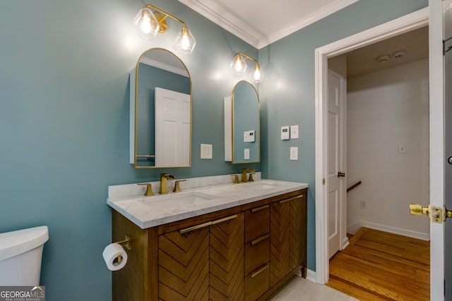 bathroom featuring vanity, toilet, hardwood / wood-style flooring, and ornamental molding