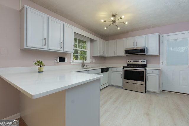 kitchen with appliances with stainless steel finishes, kitchen peninsula, and white cabinets