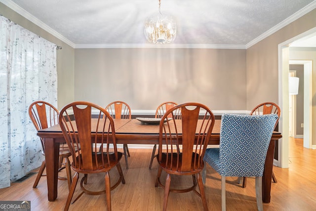 dining room with a notable chandelier, light hardwood / wood-style floors, and ornamental molding