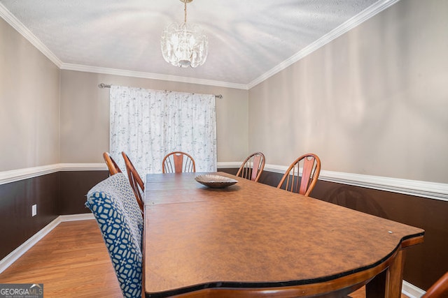 dining area featuring a chandelier, light hardwood / wood-style flooring, and ornamental molding