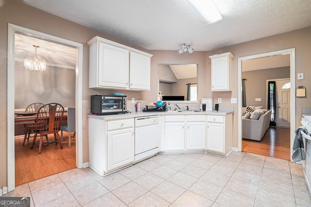 kitchen featuring an inviting chandelier, white cabinetry, white dishwasher, and light tile patterned floors