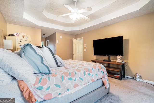 bedroom featuring ceiling fan, a raised ceiling, and light carpet