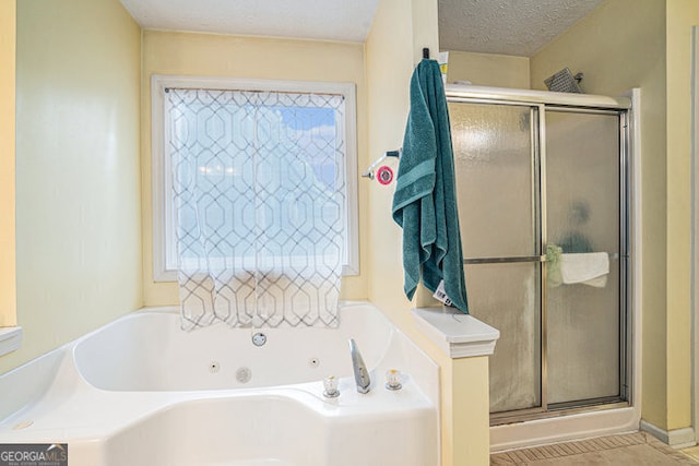 bathroom featuring a textured ceiling and shower with separate bathtub