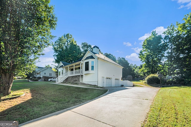 view of side of home featuring a garage, a porch, and a yard