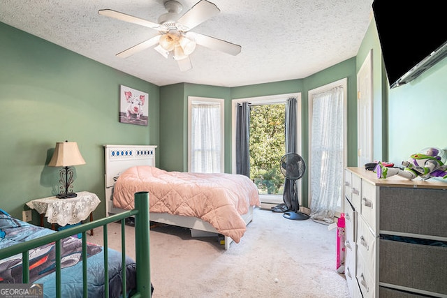 carpeted bedroom featuring a textured ceiling and ceiling fan